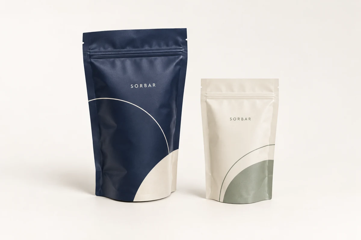 Concept samples of navy and cream stand-up pouches with curved bottom gussets and precise flexible-film seals.