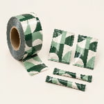 A rollstock film reel sits beside flat sachets and stick packs made from matching printed film.