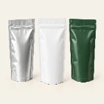 Three stand-up pouches in metallic silver foil, matte white laminate and glossy forest green film, with zippers and bottom gussets